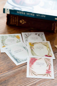 Bookplates with floral designs and books on wood table