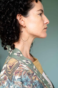 Woman wearing brass hoop earrings