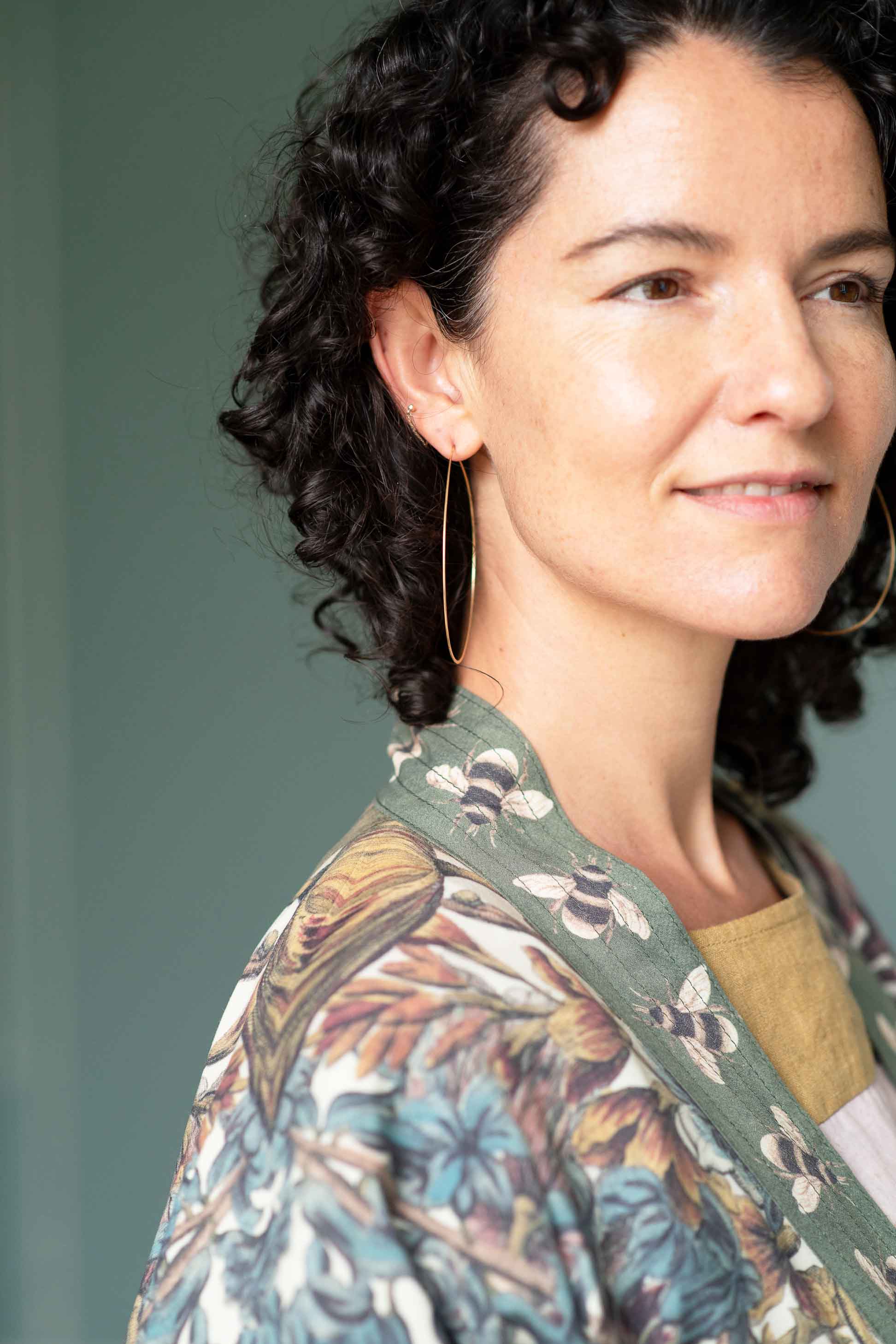 Woman wearing brass hoop earrings