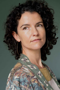 Woman wearing brass hoop earrings