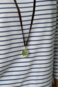 Oval crystal locket necklace on striped shirt