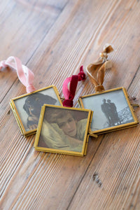 Framed photos with velvet ribbon, on wooden surface