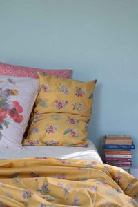 Floral bedding with yellow pillows and books