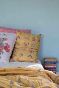 Floral bedding with yellow pillows and books