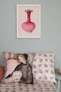 Woman with dog pillow and framed pink flower art