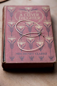 Brass hoop earrings on vintage book