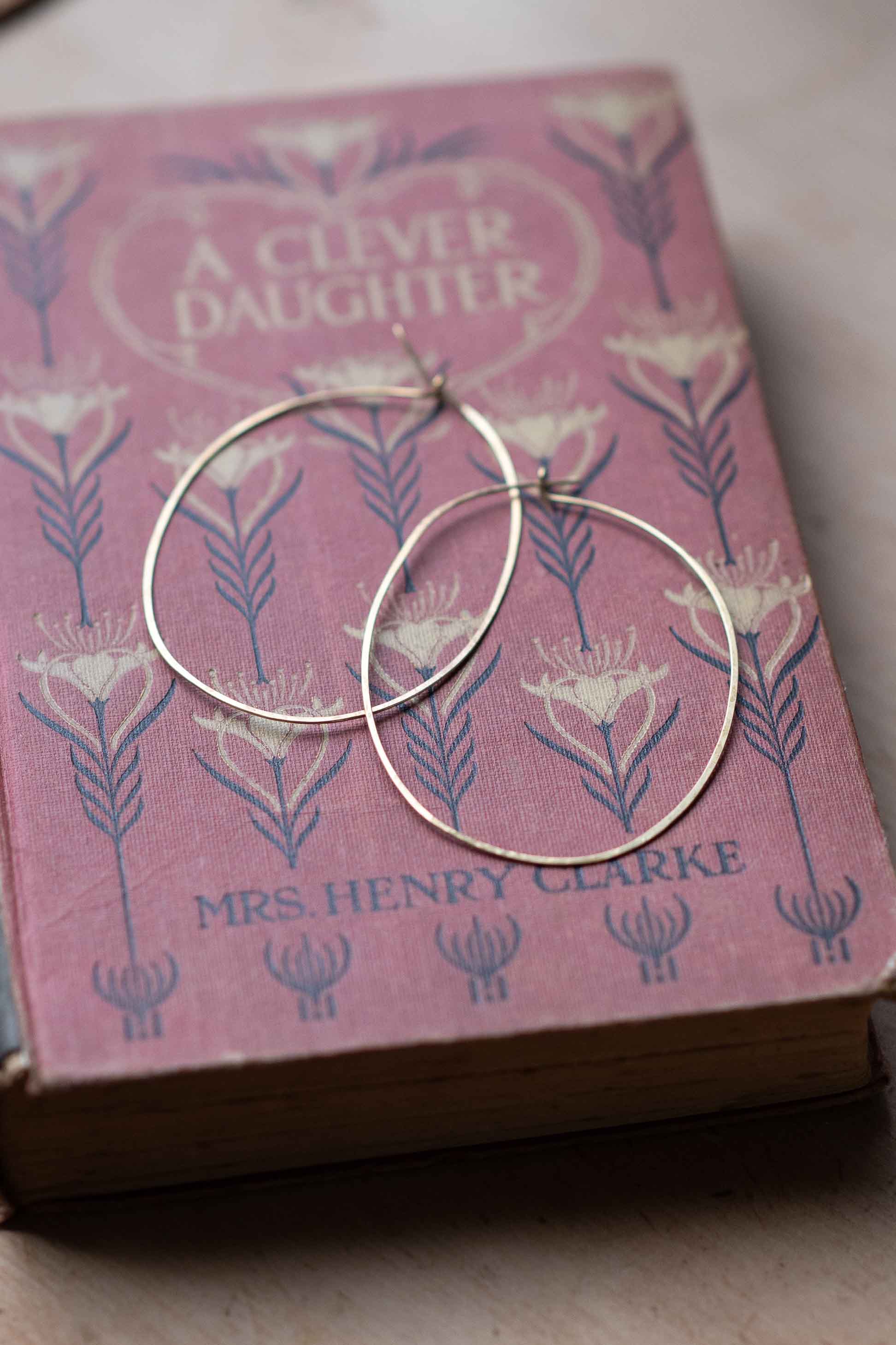 Brass hoop earrings on a vintage book