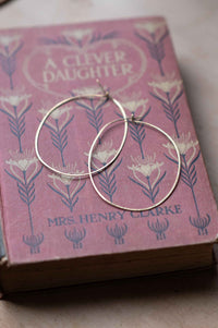 Brass hoop earrings on a vintage book