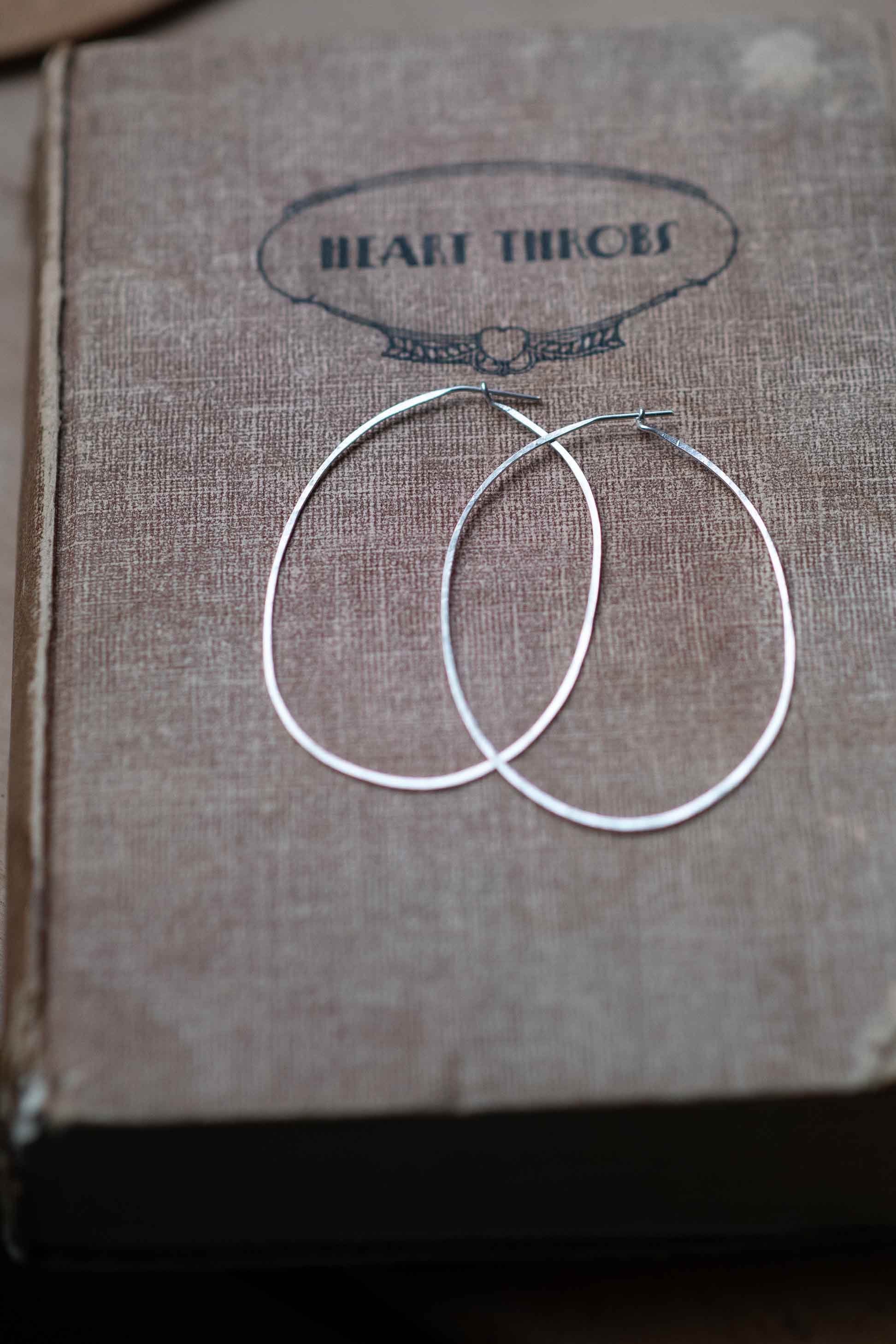 Silver hoop earrings on book