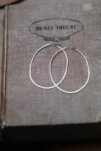 Silver hoop earrings on book