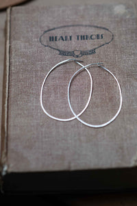 Silver hoop earrings on book