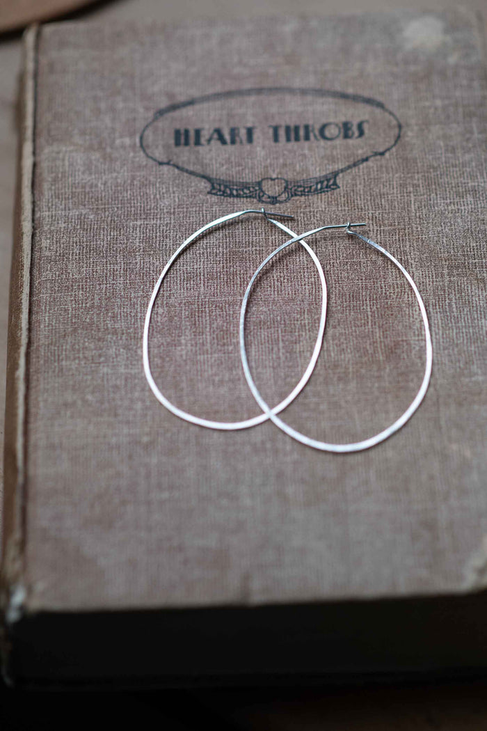 Silver hoop earrings on book