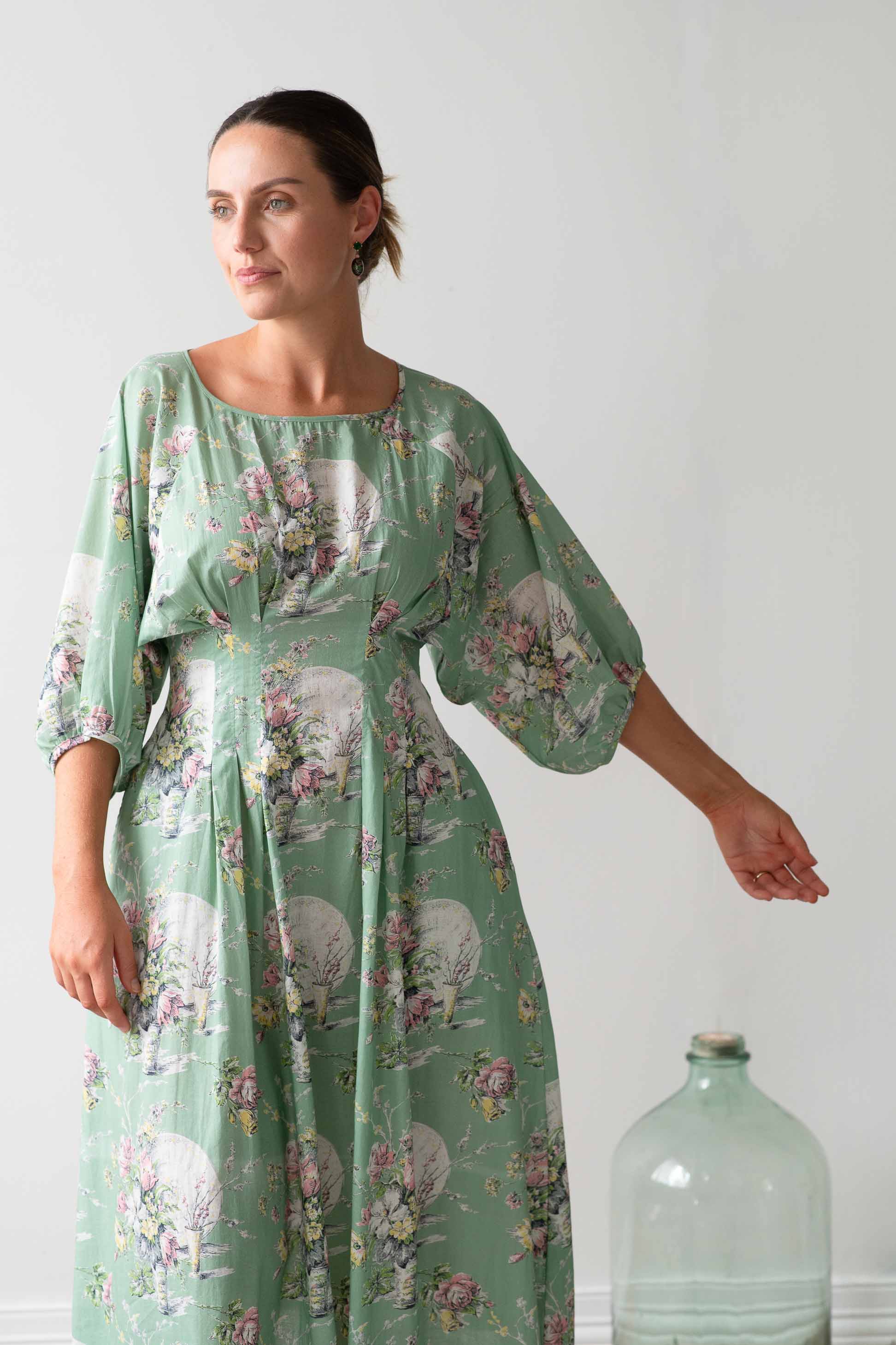 Faith Newlyn floral dress with woman and bottle