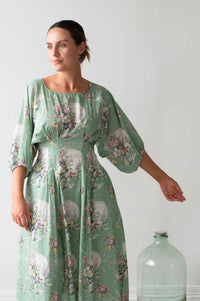 Faith Newlyn floral dress with woman and bottle