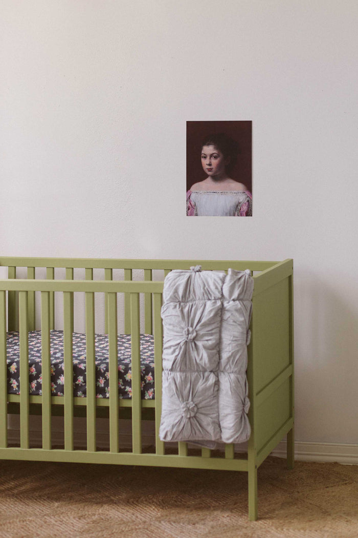 Grey marle cot quilt and prairie cot sheet in kids room with art print.