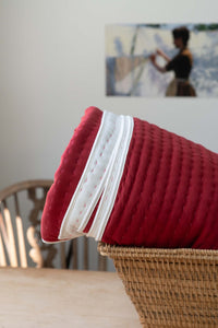 Garnet Kantha quilt with white trim in basket