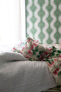 Kantha quilt & floral pelargonium sheets on bed