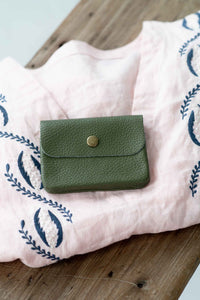 Moss green leather coin purse on pink cloth