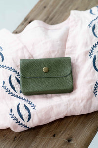 Moss green leather coin purse on pink cloth