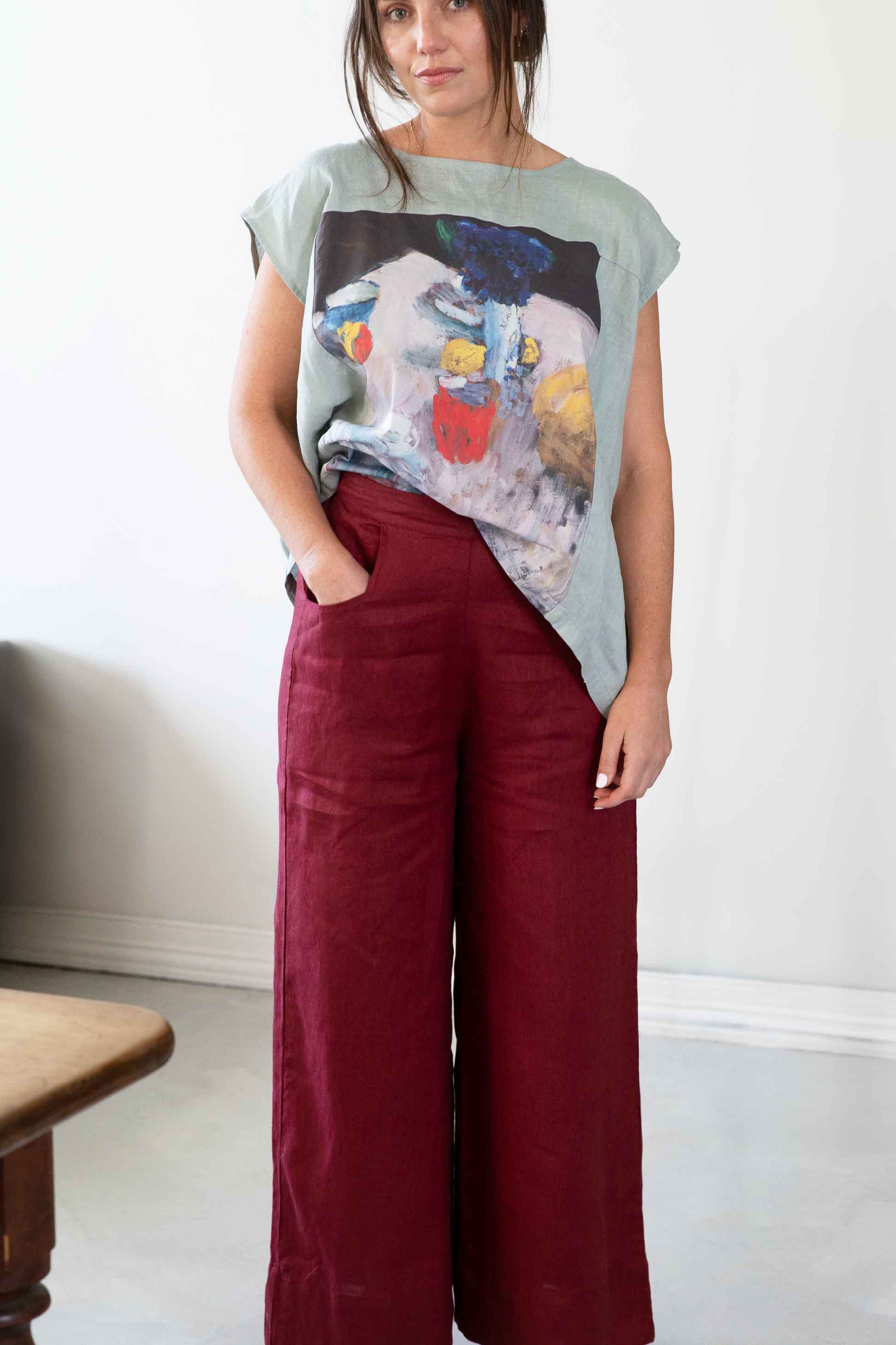 Woman in red pants and art print top, Peggy Still Life Ollie Red