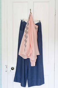 Simona Top & Ollie Indigo pants hanging on a door.