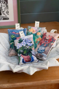Still life of scented sachets with floral designs.