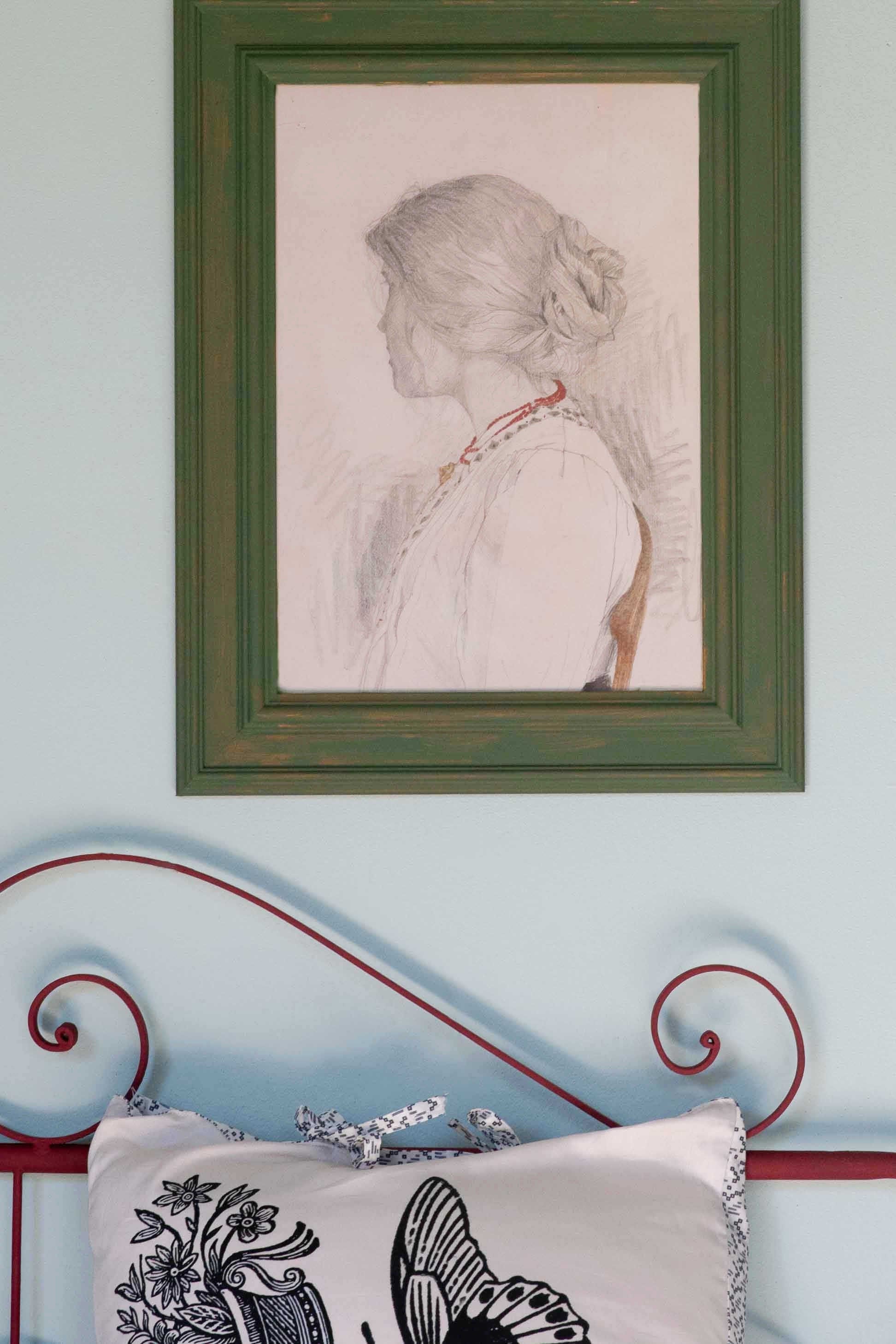 Woman's portrait in green frame, bedroom study.