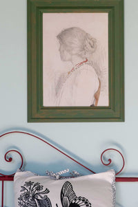 Woman's portrait in green frame, bedroom study.