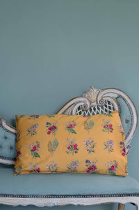 Summerland Pillowcase with floral print on a teal chaise.