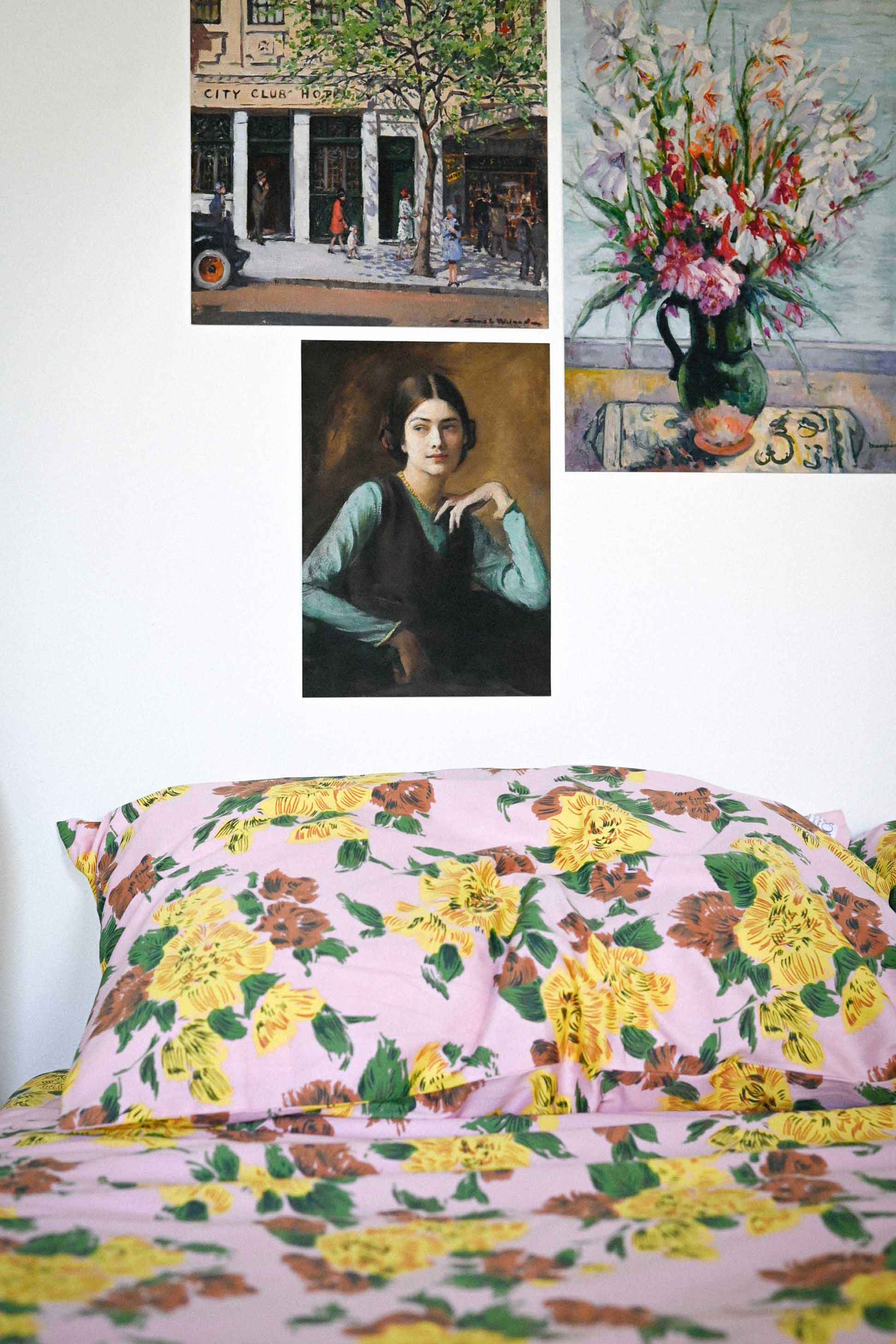 Zinnia art print set with Paris end scene & floral art, above floral bedding.
