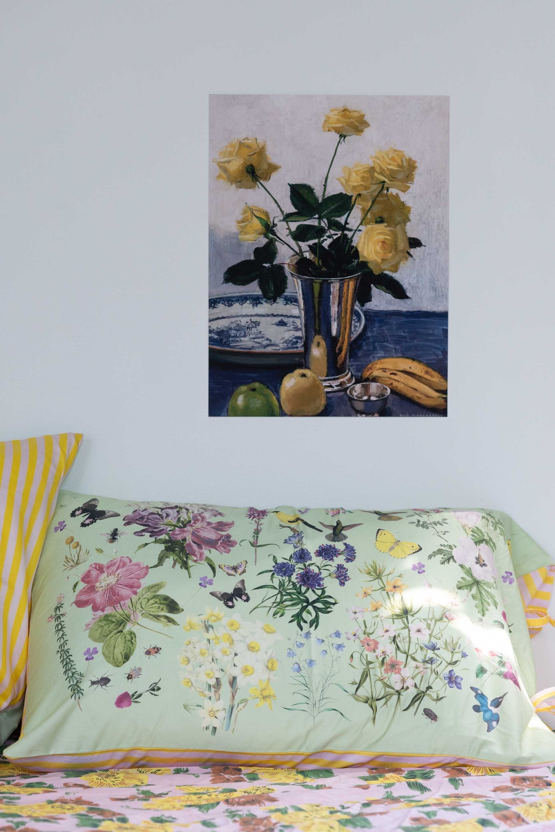 Still life with yellow roses in silver vase and floral pillow