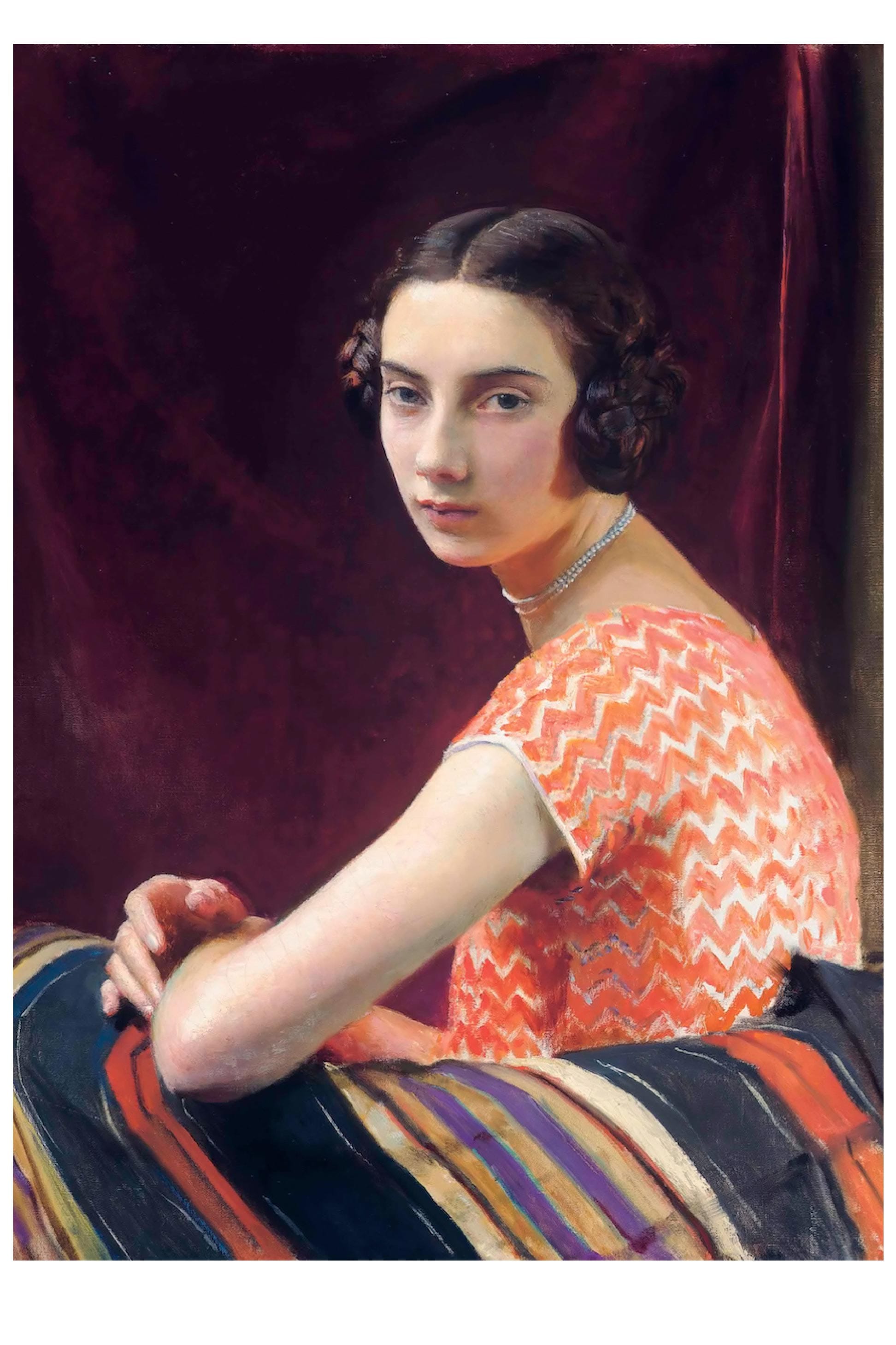 Portrait of a woman in a patterned dress and jewelry.