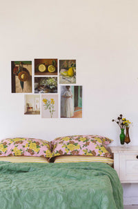 Green quilt, Zinnia pillowcase set, and art prints in a busy garden bedroom.