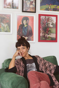Woman in Ash Rose corduroy pants, with art prints.